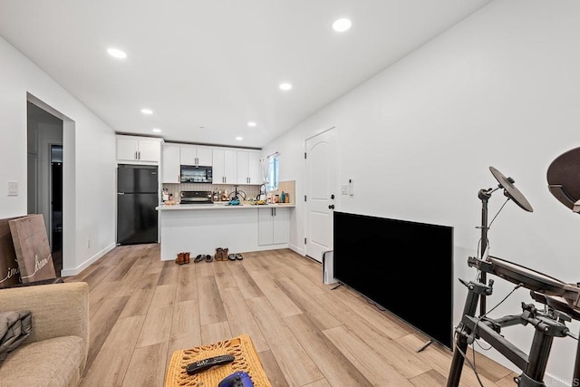 1990 Harrison Ave, San Diego, CA 92113 - kitchen featuring a peninsula, black appliances, recessed lighting, light wood finished floors, and white cabinetry