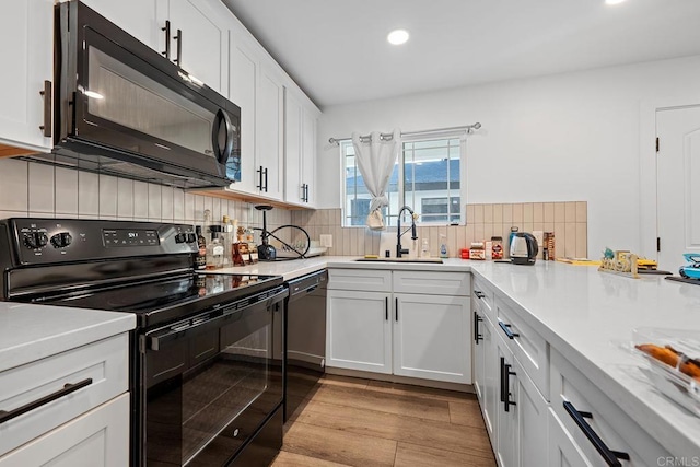 1990 Harrison Ave, San Diego, CA 92113 - kitchen featuring recessed lighting, a sink, black appliances, light wood-style floors, and white cabinets