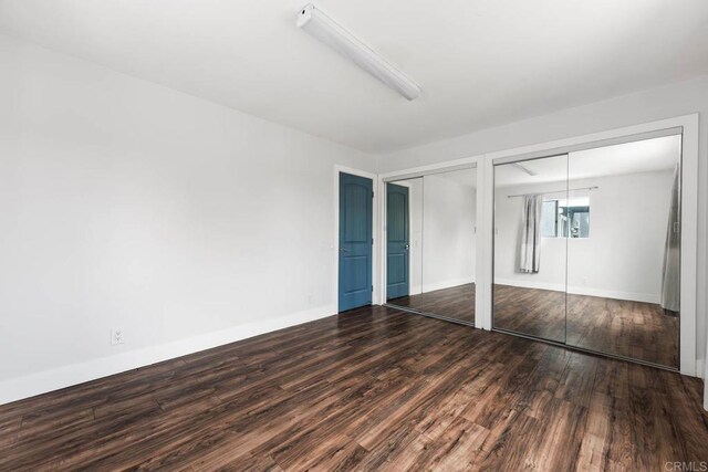 1990 Harrison Ave, San Diego, CA 92113 - unfurnished bedroom featuring two closets, wood finished floors, and baseboards