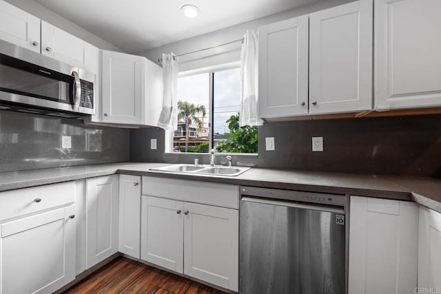 1990 Harrison Ave, San Diego, CA 92113 - kitchen with a sink, stainless steel appliances, dark wood finished floors, white cabinetry, and decorative backsplash