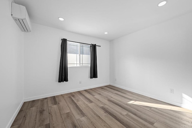 1990 Harrison Ave, San Diego, CA 92113 - spare room with recessed lighting, wood finished floors, baseboards, and an AC wall unit