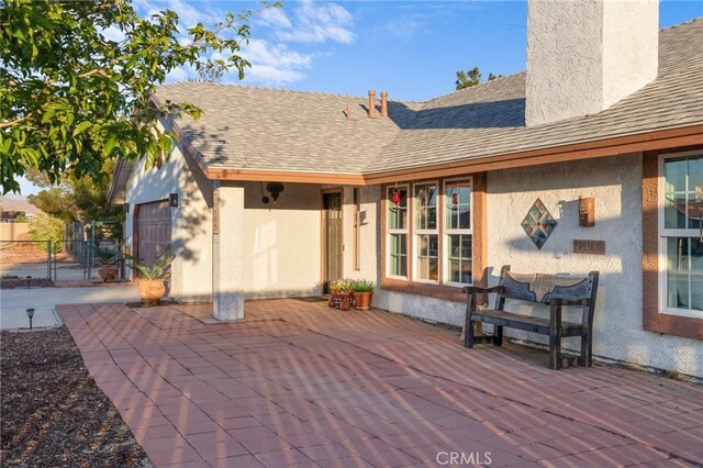 21089 Ottawa Rd, Apple Valley, CA 92308 - rear view of house with fence, a shingled roof, stucco siding, and a chimney