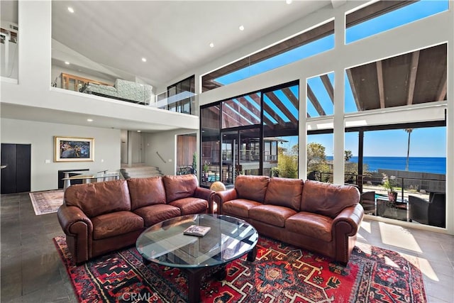 living room featuring a water view, recessed lighting, and a high ceiling