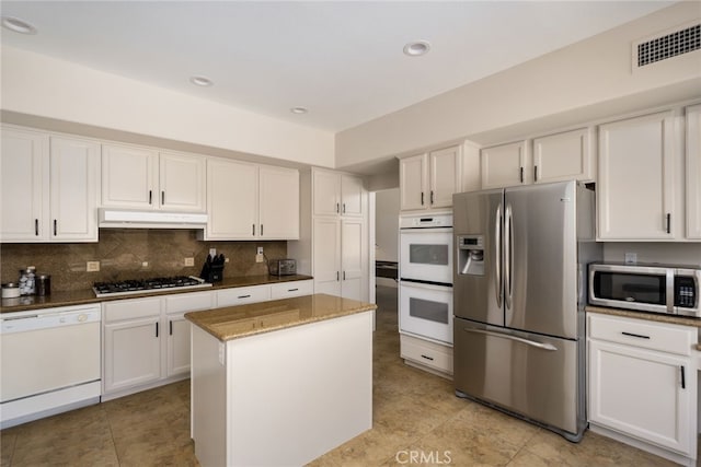 48674 Acropolis St, Indio, CA 92201 - kitchen with appliances with stainless steel finishes, under cabinet range hood, dark stone countertops, white cabinets, and recessed lighting