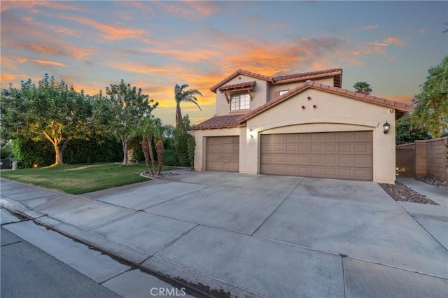 48674 Acropolis St, Indio, CA 92201 - mediterranean / spanish house featuring a tiled roof, driveway, stucco siding, and a garage
