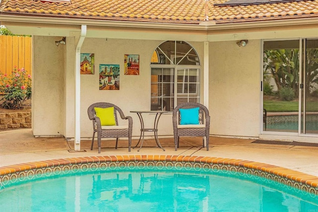 outdoor pool featuring a patio and fence