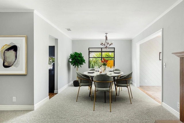 carpeted dining room featuring crown molding, a notable chandelier, baseboards, and visible vents