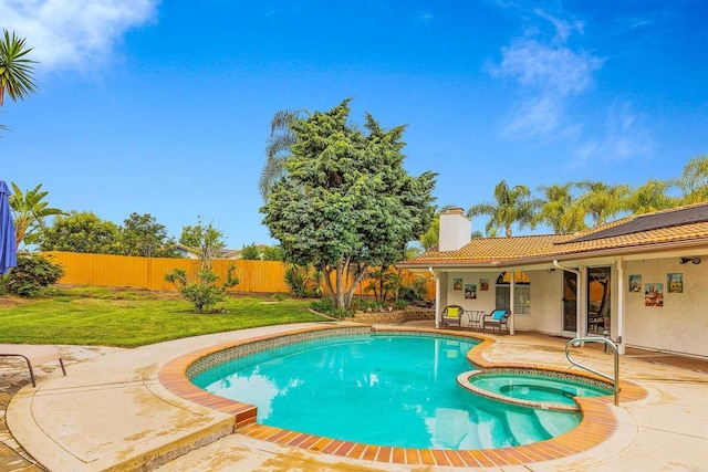 view of pool featuring a lawn, a patio area, a pool with connected hot tub, and a fenced backyard
