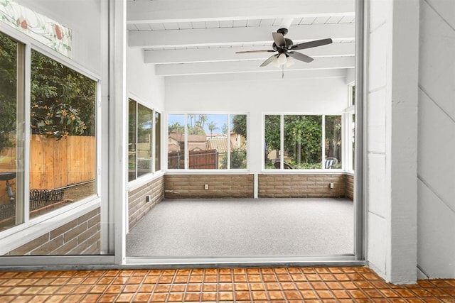 unfurnished sunroom with beam ceiling and ceiling fan