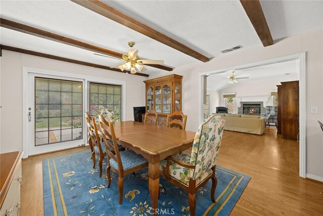 15723 La Belle St, Hacienda Heights, CA 91745 - dining space featuring a ceiling fan, light wood-type flooring, visible vents, a lit fireplace, and beam ceiling