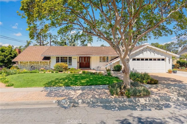 15723 La Belle St, Hacienda Heights, CA 91745 - ranch-style house featuring an attached garage, stone siding, a chimney, a front yard, and driveway