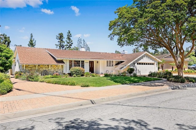 15723 La Belle St, Hacienda Heights, CA 91745 - single story home featuring board and batten siding, a tiled roof, a garage, stone siding, and a front yard
