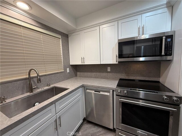22723 Maple Ave, Torrance, CA 90505 - kitchen featuring stainless steel appliances, light countertops, backsplash, and white cabinetry