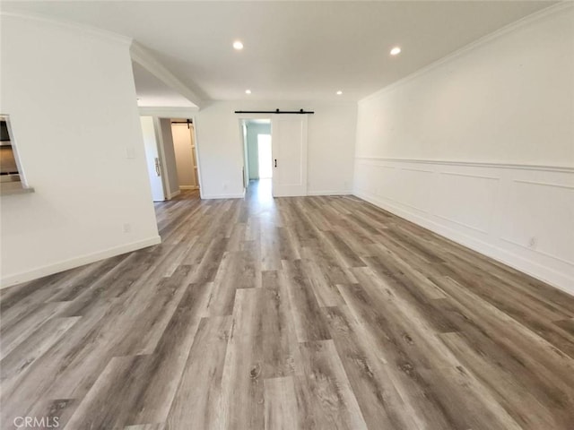 22723 Maple Ave, Torrance, CA 90505 - empty room featuring a barn door, crown molding, wood finished floors, and recessed lighting
