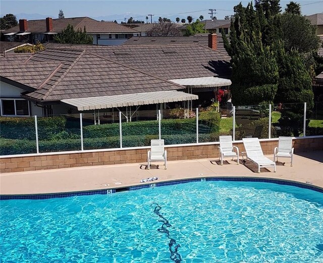 pool with a patio and fence