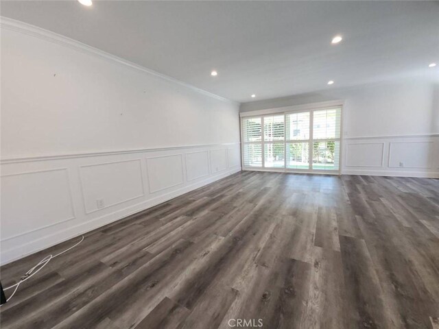 interior space featuring ornamental molding, a decorative wall, and wainscoting