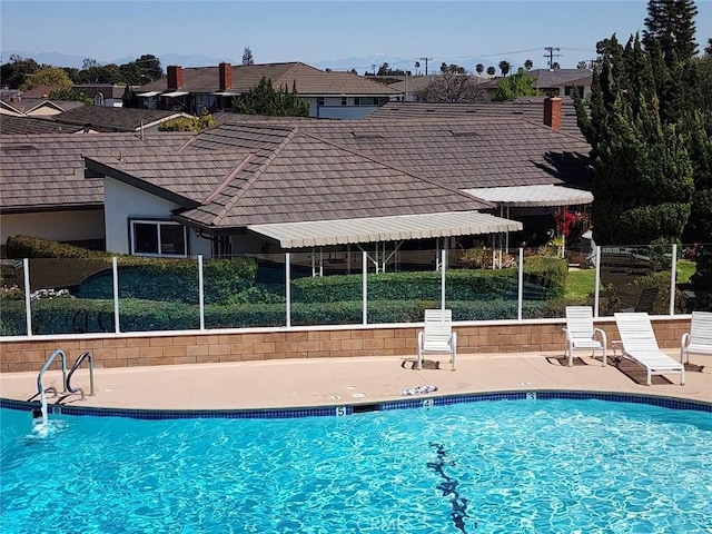 community pool featuring a patio and fence