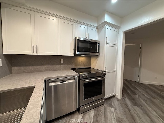 22723 Maple Ave, Torrance, CA 90505 - kitchen with appliances with stainless steel finishes, dark wood finished floors, white cabinetry, light countertops, and tasteful backsplash