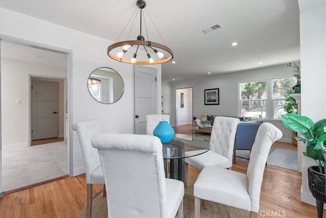 dining area with recessed lighting, baseboards, an inviting chandelier, visible vents, and light wood-type flooring