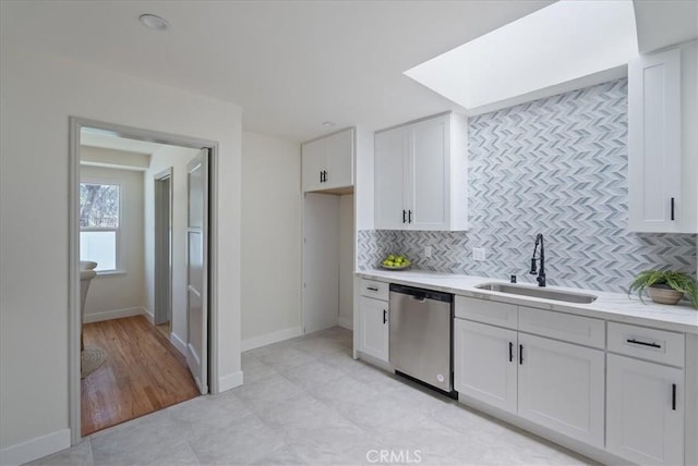 kitchen with backsplash, white cabinets, a sink, and dishwasher