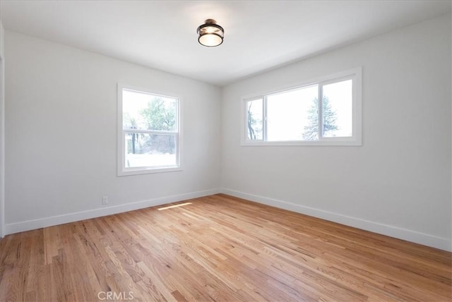 unfurnished room featuring visible vents, baseboards, and light wood-style flooring