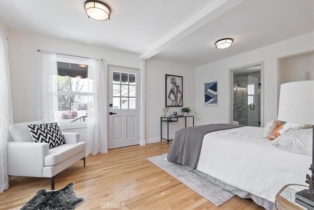 bedroom featuring connected bathroom and light wood-style floors
