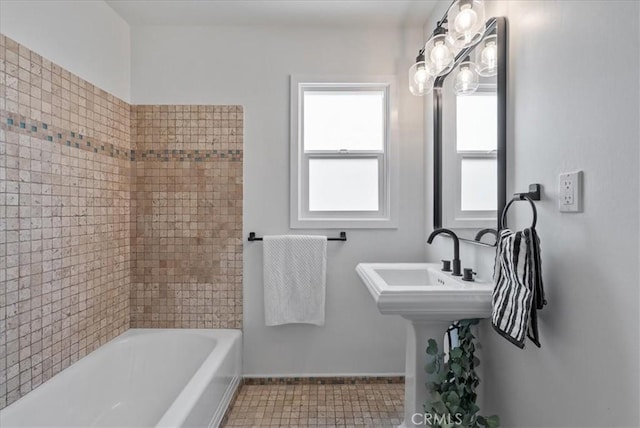 bathroom featuring tile patterned flooring, tub / shower combination, and baseboards