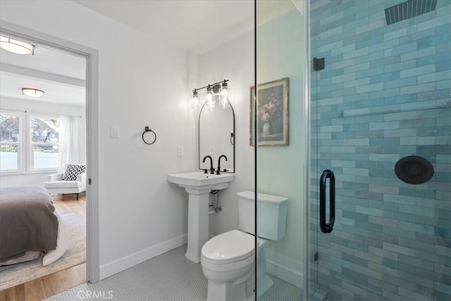 ensuite bathroom featuring baseboards, toilet, a shower stall, tile patterned floors, and connected bathroom