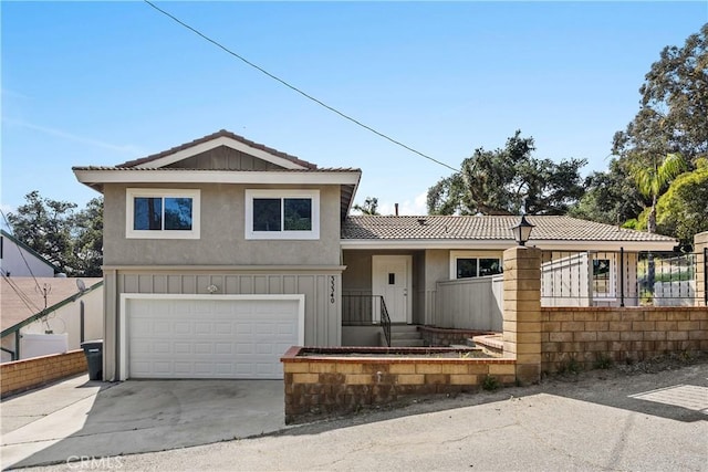 tri-level home featuring a tile roof, concrete driveway, an attached garage, and stucco siding