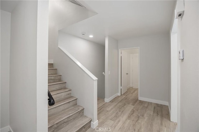 stairs with recessed lighting, baseboards, and wood finished floors