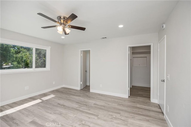 33340 Gisborne Way, Lake Elsinore, CA 92530 - unfurnished bedroom with a walk in closet, light wood-style floors, recessed lighting, a ceiling fan, and a closet