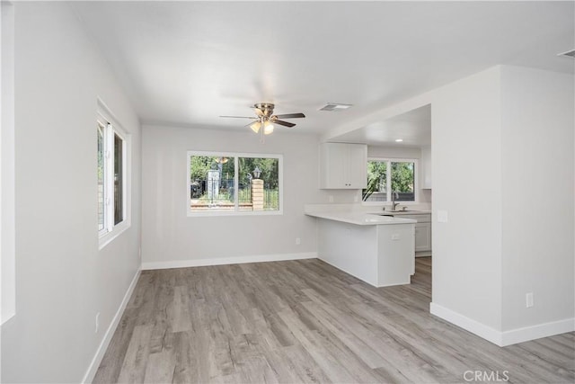 unfurnished living room featuring baseboards, ceiling fan, light wood-style flooring, and visible vents