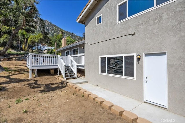 33340 Gisborne Way, Lake Elsinore, CA 92530 - view of property exterior with a deck with mountain view, stucco siding, and stairway