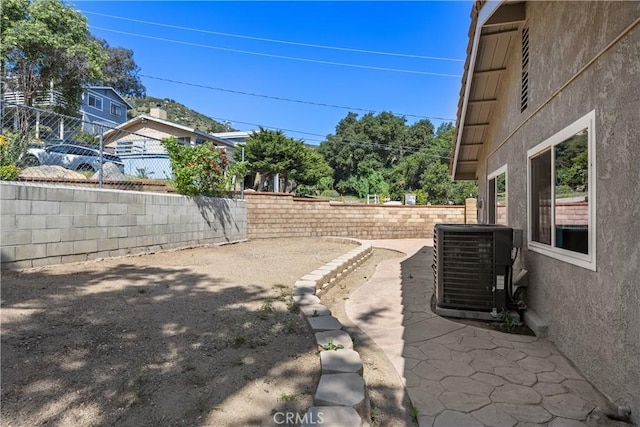 view of yard featuring central AC, a patio area, and fence
