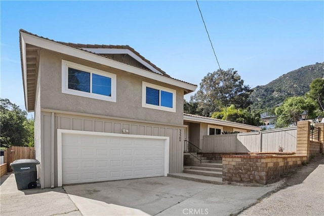 33340 Gisborne Way, Lake Elsinore, CA 92530 - view of front facade with stucco siding, a mountain view, driveway, and a garage
