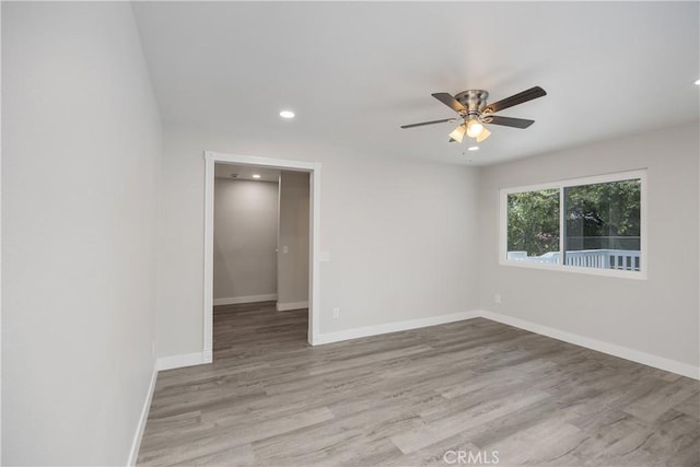 empty room featuring ceiling fan, wood finished floors, baseboards, and recessed lighting