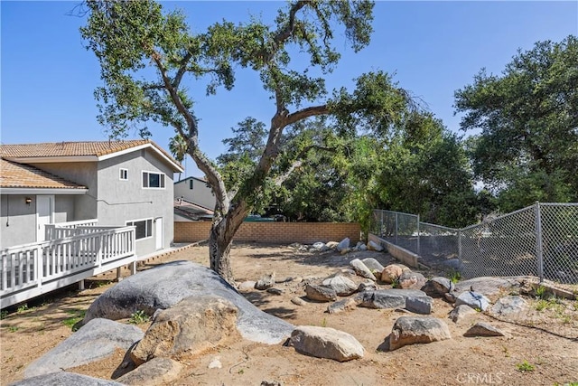 view of yard featuring fence and a wooden deck