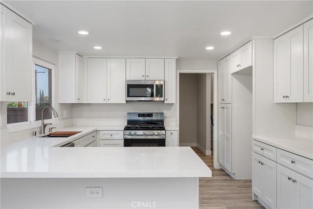 33340 Gisborne Way, Lake Elsinore, CA 92530 - kitchen featuring appliances with stainless steel finishes, recessed lighting, light wood-style flooring, light countertops, and white cabinets