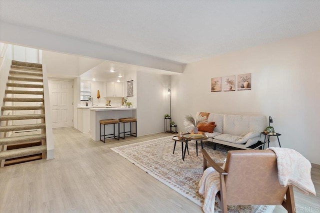 living area with stairs and light wood-style floors