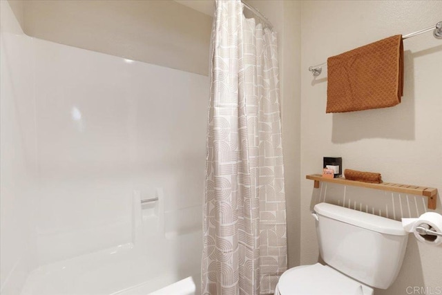 bathroom featuring toilet and a shower with shower curtain