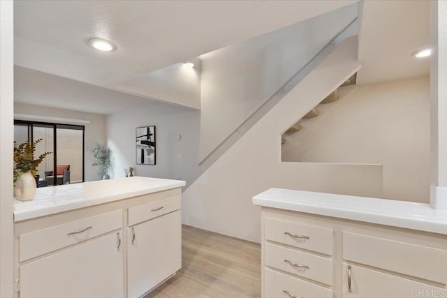 kitchen with recessed lighting, tile countertops, light wood-type flooring, and white cabinets