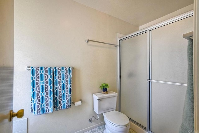 full bathroom featuring toilet and a shower stall