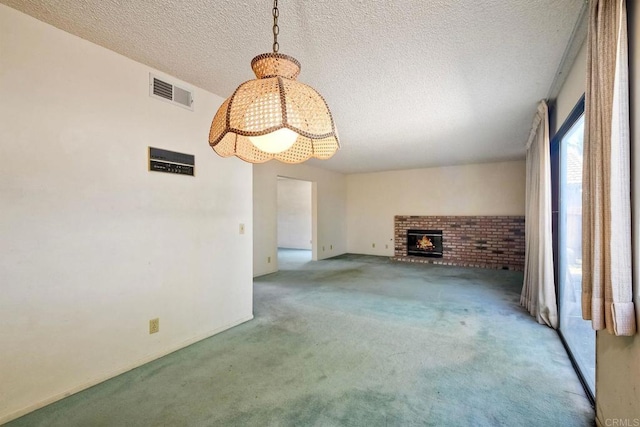 unfurnished living room with a textured ceiling, carpet, an inviting chandelier, visible vents, and a fireplace
