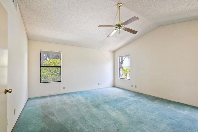 empty room featuring a textured ceiling, a ceiling fan, carpet floors, and vaulted ceiling