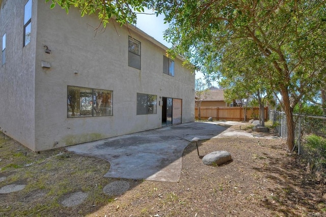 back of property with a patio, stucco siding, and a fenced backyard