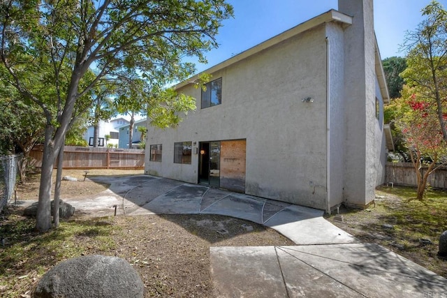 back of house featuring a patio, stucco siding, and a fenced backyard