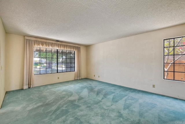 carpeted empty room with a textured ceiling