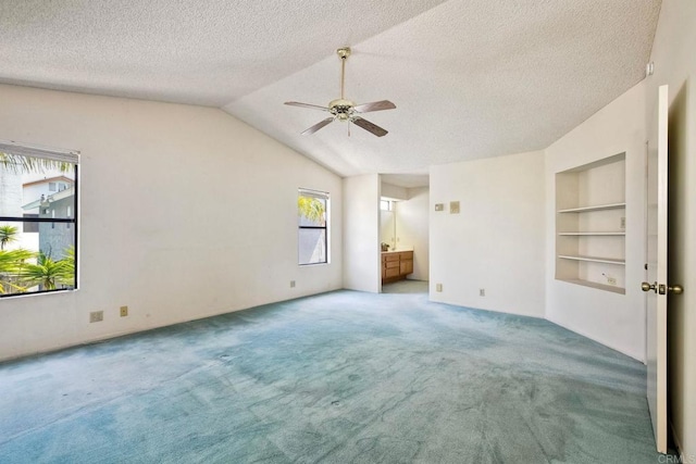 unfurnished bedroom featuring a ceiling fan, carpet floors, a textured ceiling, ensuite bath, and vaulted ceiling