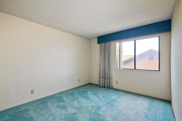 carpeted empty room with a textured ceiling