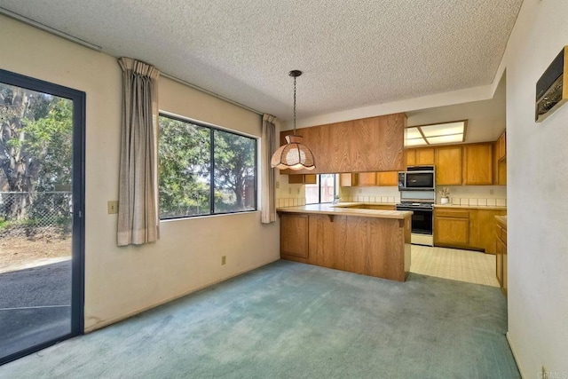 kitchen featuring brown cabinets, a healthy amount of sunlight, a textured ceiling, and black range with gas stovetop